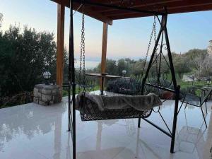 a porch swing with a bed on a patio at Tepeboz Stone House Tuscany in Karaburun in Karaburun