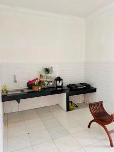 a kitchen with a counter with a sink and a chair at Villa Dedaun Batu in Batu