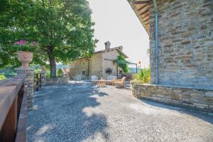 un edificio de piedra con valla, mesas y sillas en Suite con Bagno in villa esclusiva - Urbino, en Urbino