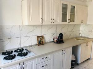a kitchen with white cabinets and a stove top oven at Apartament Diana in Tulcea +5 photos
