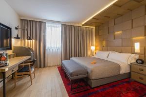 a hotel room with a large bed and a desk at Canopy by Hilton Zagreb City Centre in Zagreb
