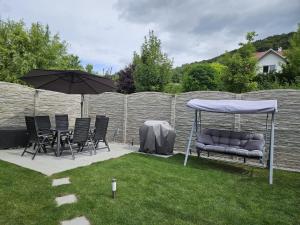 a patio with chairs and an umbrella in a yard at Ferienhaus Vagner in Furth