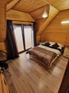 a bedroom with a bed in a wooden cabin at Domki całoroczne KATRINA in Krynica Morska