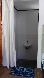 a bathroom with a white shower curtain and a sink at Naca Homestay in Manado