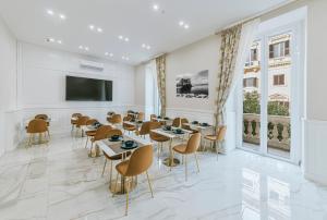 ナポリにあるGentile Suite & Spa Vomeroのダイニングルーム(テーブル、椅子、薄型テレビ付)
