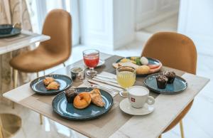 ナポリにあるGentile Suite & Spa Vomeroのペストリーとコーヒーの盛り合わせが備わるテーブル