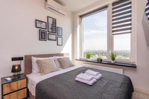 1 dormitorio con 1 cama con 2 toallas en MYFREEDOM Видові Апартаменти ВДНГ, en Kiev