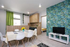a kitchen and dining room with a table and a tv at Apartament Piwna 13 in Gliwice