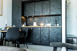 kuchnia z czarnymi szafkami i czarnymi krzesłami w obiekcie Apartament Warmiński Port 50m od jeziora w Olsztynie