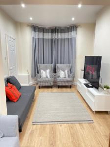 a living room with two couches and a flat screen tv at Breeze Hill Lodge - Central to Liverpool City Centre - Anfield - Goodison in Liverpool