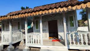 an old house with a red arrow on the porch at Omah Kayu Palagan in Ngaglik