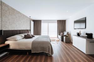 een slaapkamer met een bed en een flatscreen-tv bij Cosmopolite Hotel Nieuwpoort-Bad in Nieuwpoort
