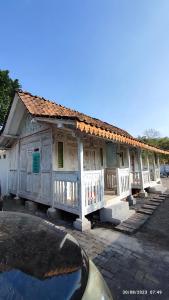 ein Gebäude mit weißen Türen und einem Dach in der Unterkunft Omah Kayu Palagan in Ngaglik