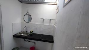 ein Badezimmer mit Waschbecken und Spiegel in der Unterkunft Omah Kayu Palagan in Ngaglik