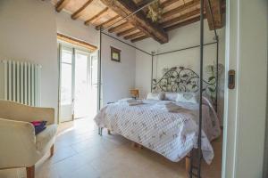 una camera con letto e testiera in ferro battuto di Ca' Gulino - Urbino - Villa con Minipiscina in Borgo Antico a Urbino