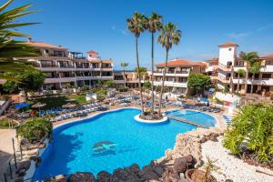 an aerial view of a resort pool with chairs and palm trees at Casa Soleil Golf del Sur in San Miguel de Abona