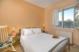 una camera con un letto bianco e una finestra di Maria’s Mansion 3 m from the SEA a Marathónas (Maratona)