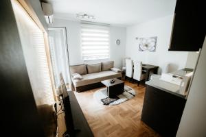 un soggiorno con divano e tavolo di Apartman Ksenija a Vrnjačka Banja