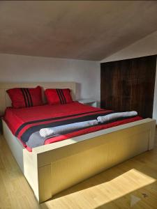 a bedroom with a large bed with red pillows at Дом Лашо всё хорошо in Tbilisi City