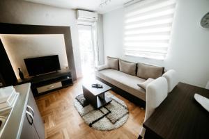 un soggiorno con divano e TV di Apartman Ksenija a Vrnjačka Banja