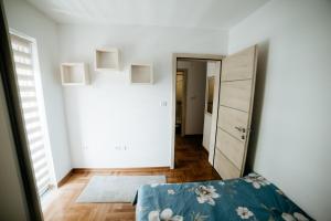 Camera bianca con letto e corridoio di Apartman Ksenija a Vrnjačka Banja