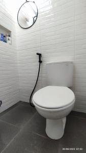 ein Badezimmer mit einer weißen Toilette und einem Spiegel in der Unterkunft Omah Kayu Palagan in Ngaglik