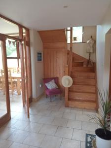 Habitación con escalera de madera y silla morada. en Coastal village retreat en Castletownshend