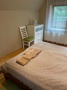ein Schlafzimmer mit einem Bett, einem Stuhl und einem Fenster in der Unterkunft Domek Letniskowy Zacisze Guciów in Guciów