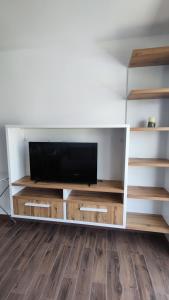 a white entertainment center with a flat screen tv at Monty studio in Bar
