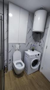 a bathroom with a toilet and a washing machine at Monty studio in Bar