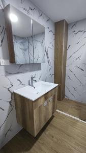 a bathroom with a sink and a marble wall at Monty studio in Bar