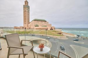 budynek z wieżą zegarową oraz stołem i krzesłami w obiekcie Apartment Sea View B14 - Mosquée Hassan II - By TheCasaEdition w mieście Casablanca