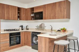 a kitchen with wooden cabinets and a washer and dryer at Apartment Sea View B14 - Mosquée Hassan II - By TheCasaEdition in Casablanca