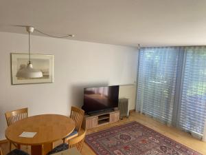 a living room with a table and a television at Haus Elke in Hard