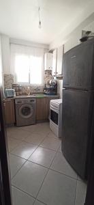 a kitchen with a stainless steel refrigerator and a stove at Séjour Paisible au Bord de la Nature. in Tangier