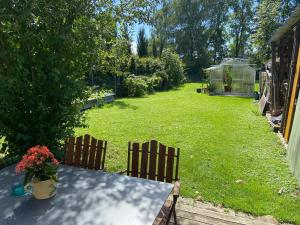 un patio con una mesa y dos sillas y un invernadero en Haus Elke, en Hard