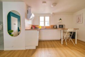a kitchen with a table and a mirror on the wall at Sweet Champagne - Centre-ville in Épernay