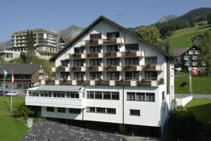 ein großes weißes Gebäude mit Fenstern und Balkonen darauf in der Unterkunft Hotel Toggenburg in Wildhaus