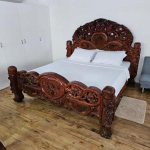 uma grande cama de madeira com lençóis brancos e almofadas em A's Place - Casaroro em Valencia