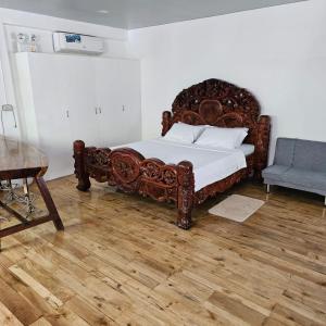 um quarto com uma grande cama de madeira e uma cadeira em A's Place - Casaroro em Valencia