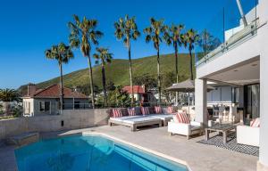 a house with a swimming pool and palm trees at Villa Legacy in Cape Town