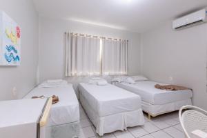 a room with two beds and a window at Hotel Mares de Iracema in Fortaleza