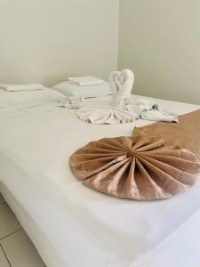 two beds with towels and a plate on a table at Hotel Mares de Iracema in Fortaleza