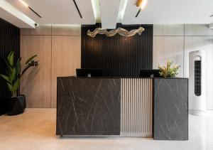 a lobby with a black reception desk with plants at DLUXE PREMIUM HOTEL in Port Harcourt