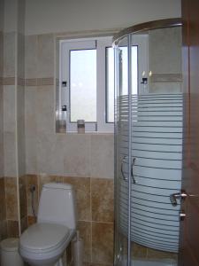 baño con aseo y 2 ventanas en Paradise Apartments en Paleokastritsa