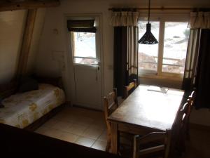 a room with a table and a bed and a window at Complejo de Cabañas Tierra de Luna in Potrerillos