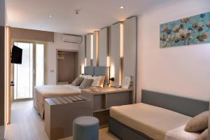 a hotel room with two beds and a couch at Hotel Colorado in Lignano Sabbiadoro