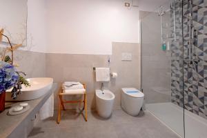 y baño con aseo, lavabo y ducha. en Hotel Colorado en Lignano Sabbiadoro
