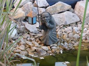 une statue d'une personne tenant une lumière dans un étang dans l'établissement Ferienwohnung Schanbacher, à Beerfelden