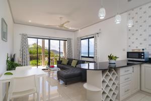 a kitchen and living room with a couch and a table at East Horizon Self Catering in Au Cap